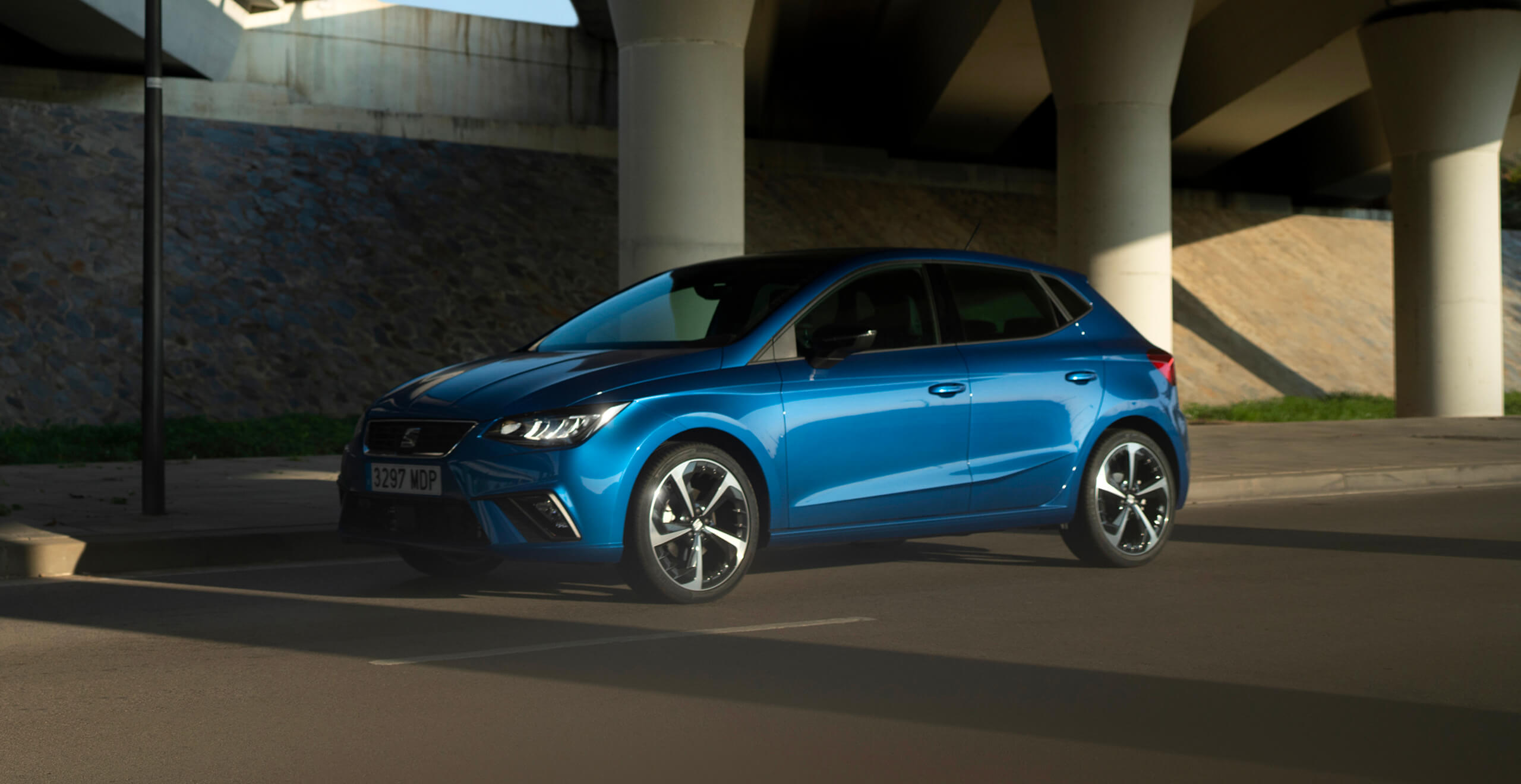 Blauwe seat ibiza FR onder een viaduct