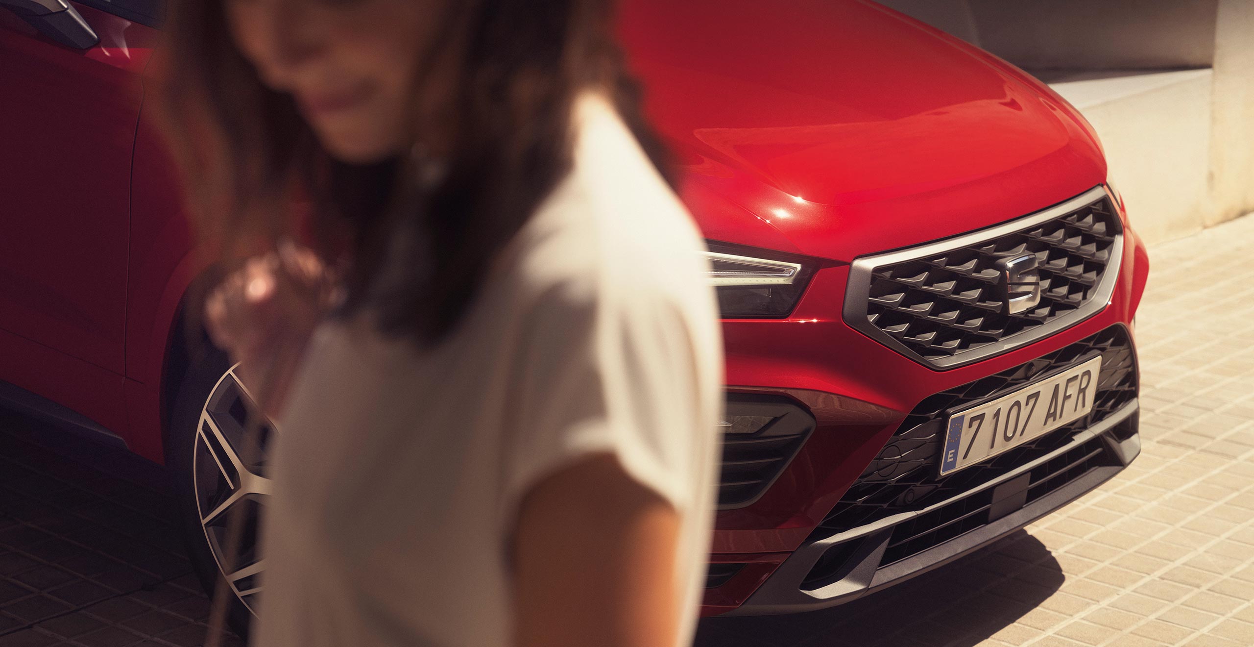 Vrouw naast een rode SEAT Ateca
