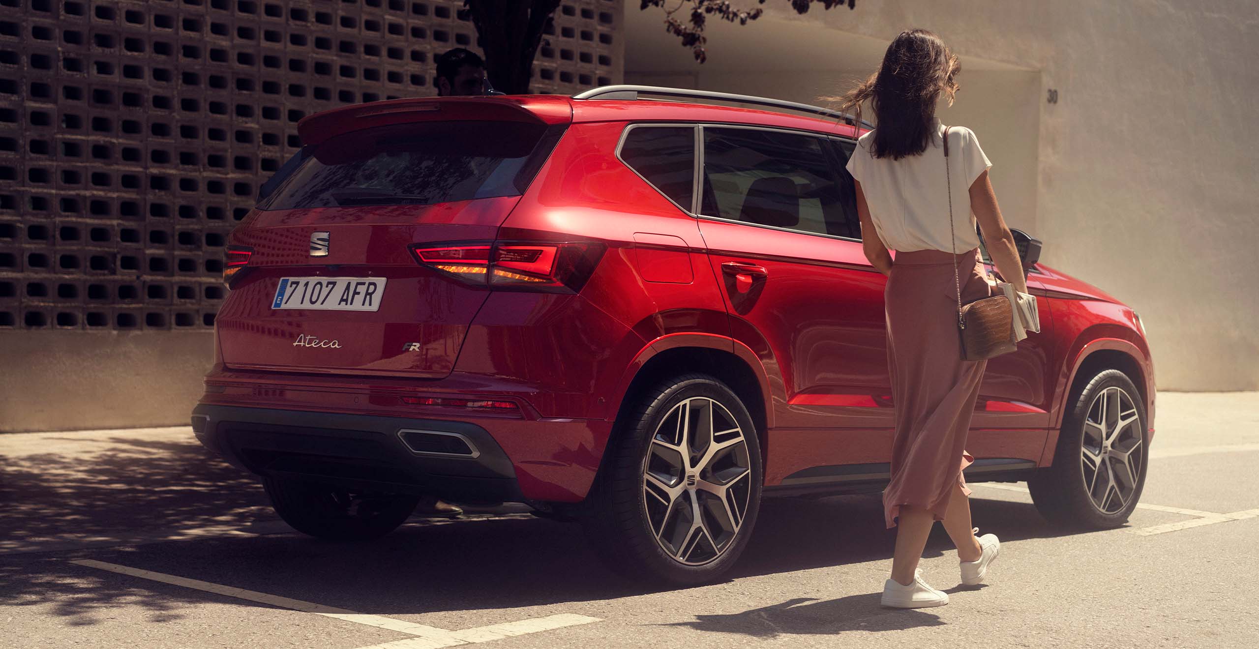 Vrouw lopend naast een rode SEAT Ateca