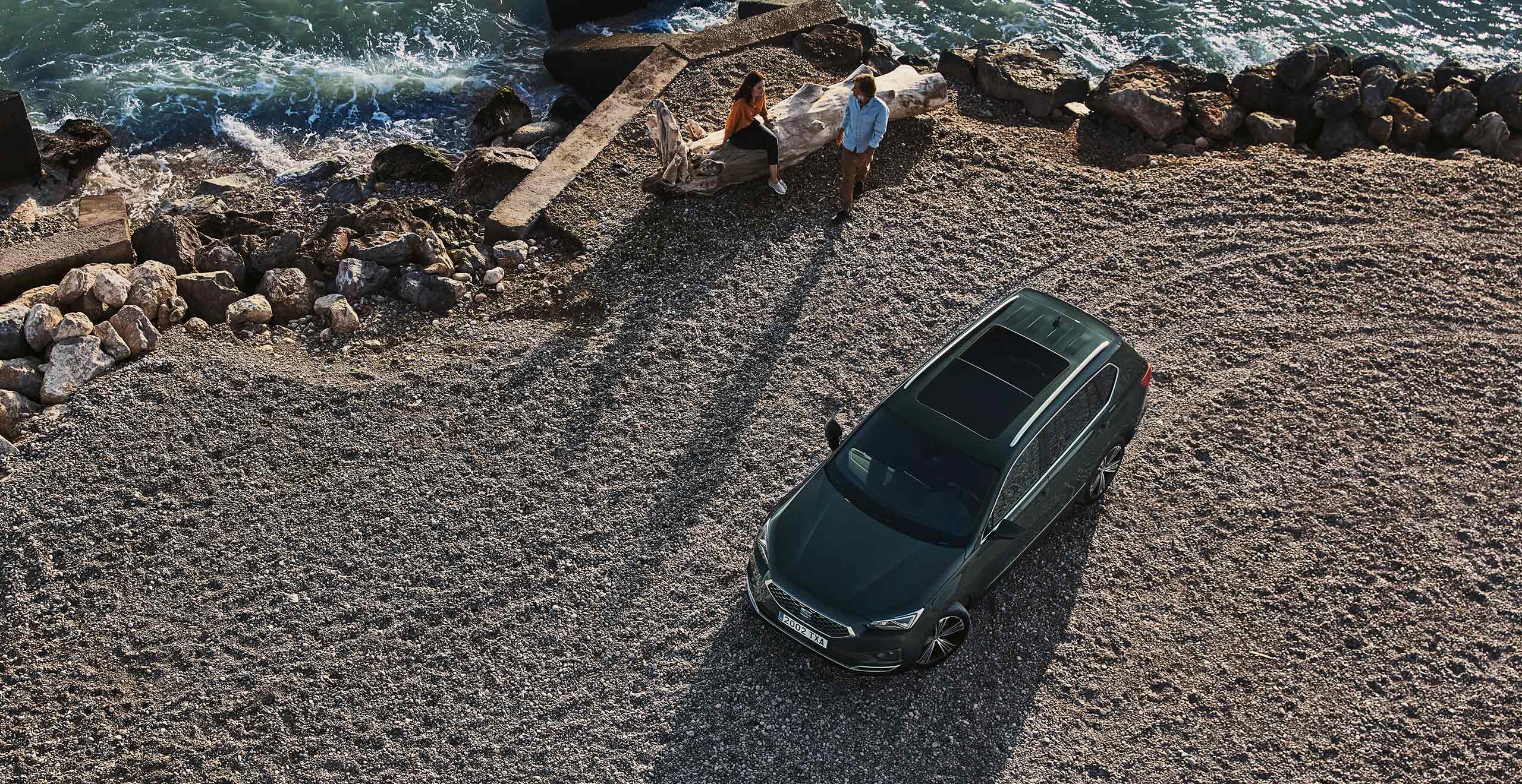 Groene SEAT Tarraco van bovenaf te zien in een zandvlakte, op de achtergrond een aantal personen