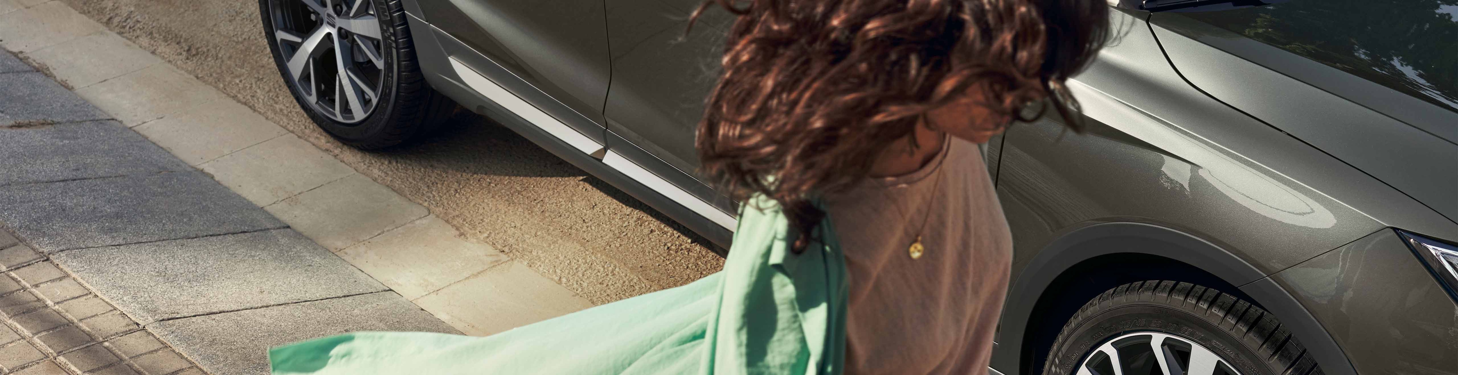 Vrouw met groen vest naast de SEAT Arona