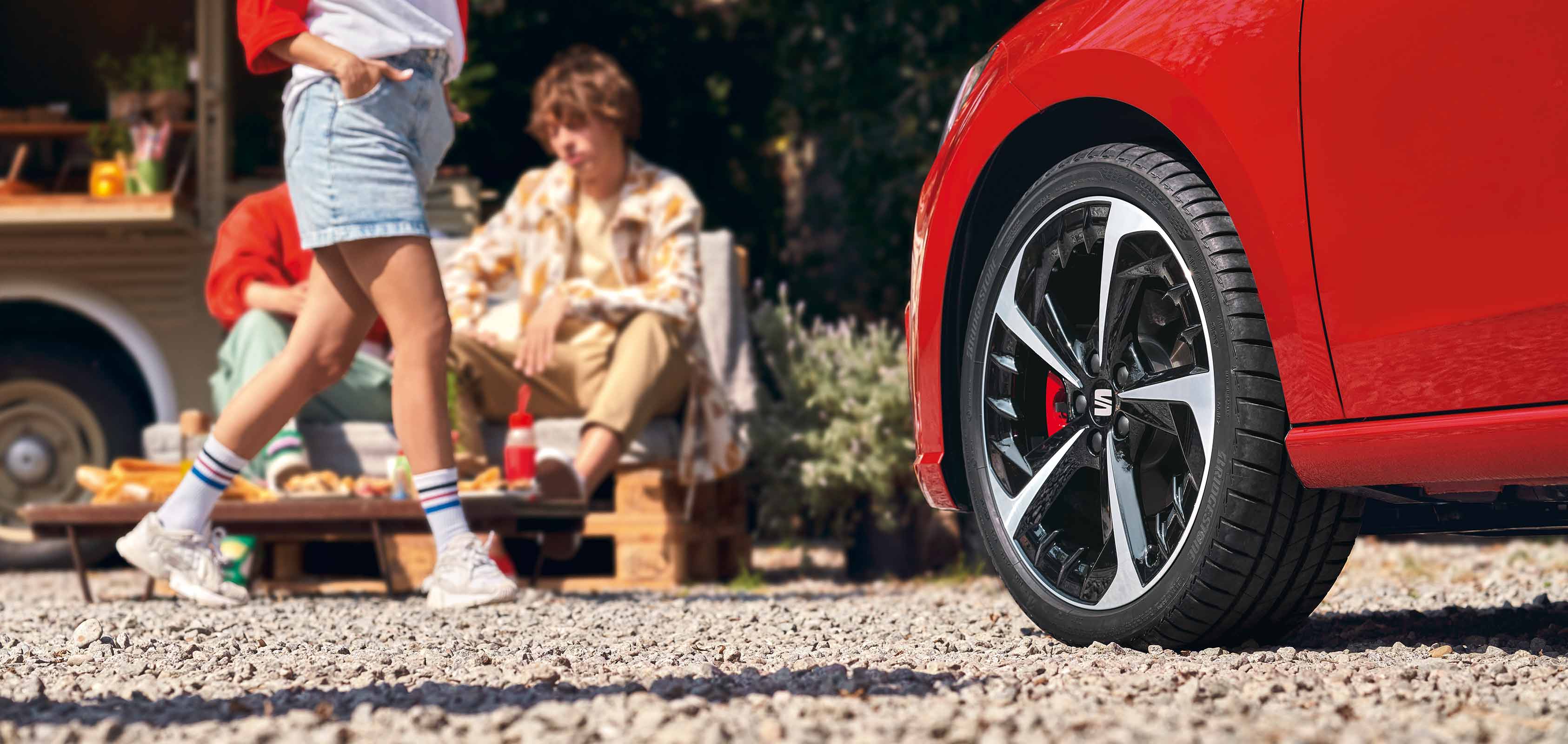 Personen naast een rode SEAT Ibiza