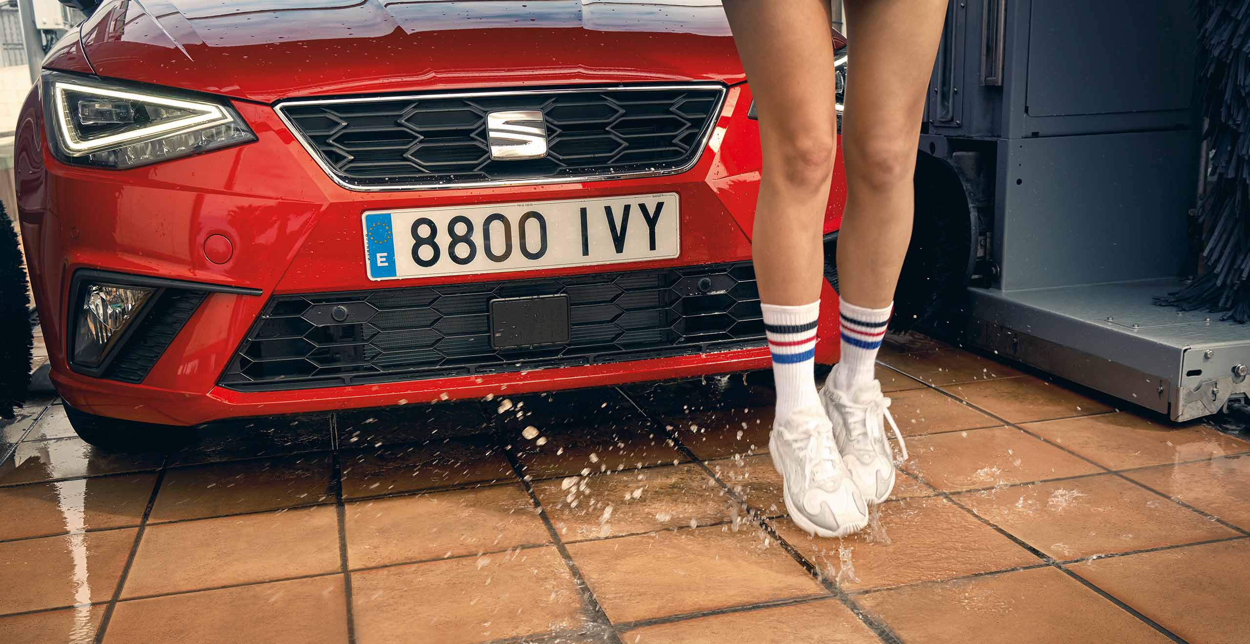 Springende vrouw voor de rode SEAT Ibiza