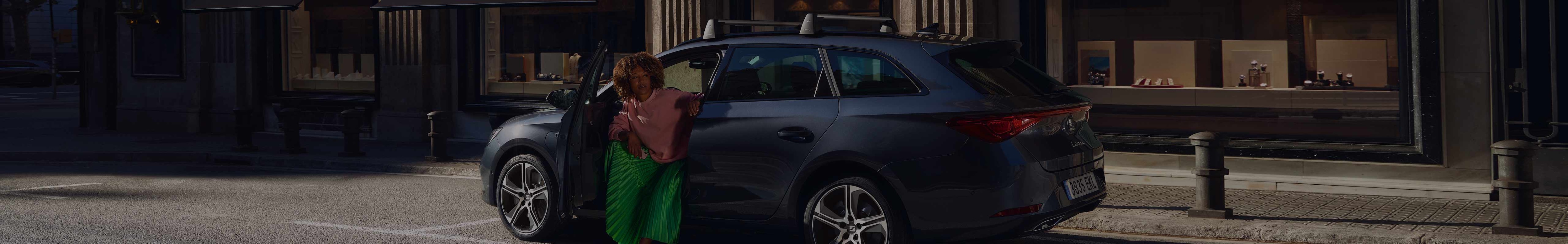 Vrouw met groene rok die uit een grijze SEAT Leon Sportstourer stapt