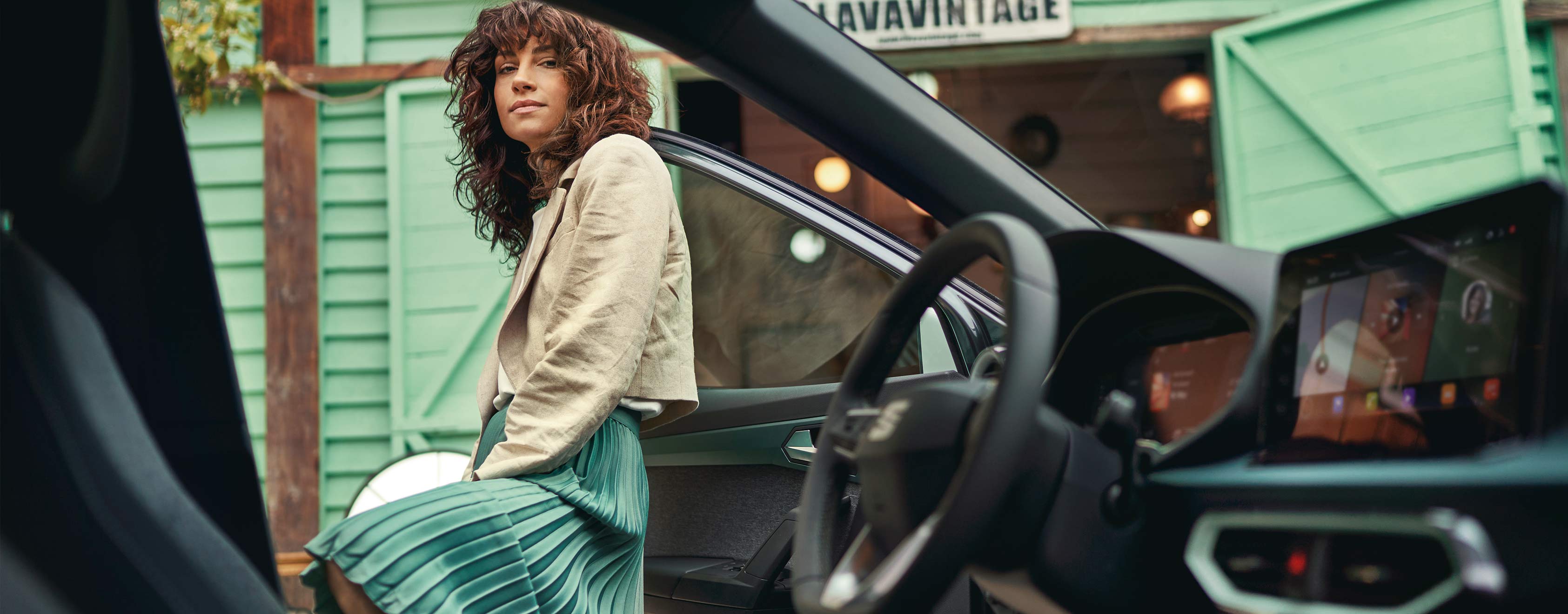 Vrouw loopt over een parkeergarage en kijkt naar een SEAT Ibiza en SEAT Arona
