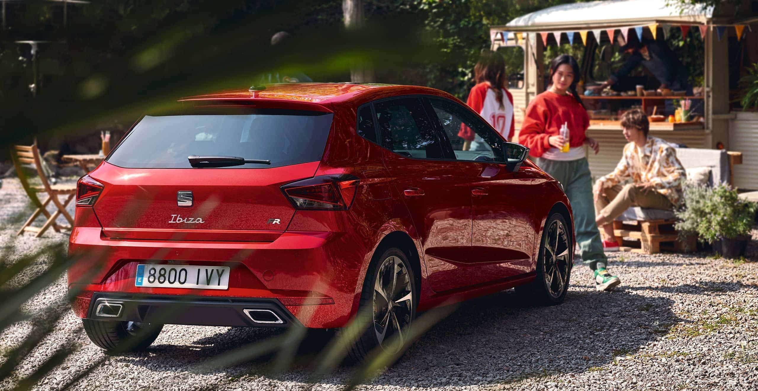 Vrouw die naast een rode SEAT Ateca bezig is met de My SEAT app